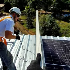 Um colaborador Ativa, usando EPIs, Instalando um painel fotovoltaicos
